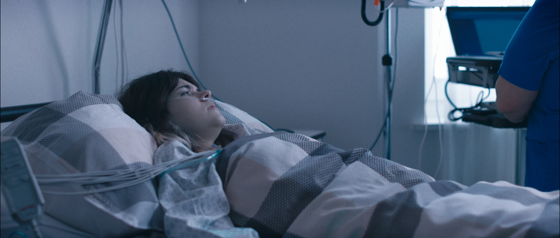 Standbild aus den Film zeigt, wie Roxy in einem Krankenbett liegt und an diverse medizinische Geräte angeschlossen ist